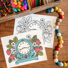 Load image into Gallery viewer, Coloring pages of a clock with strawberries on a wooden table with coloring supplies.