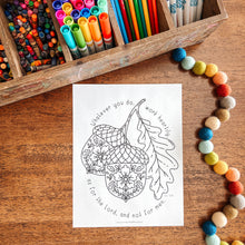 Load image into Gallery viewer, Coloring book with an acorn design on a wooden surface with markers and beads.