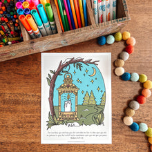 Load image into Gallery viewer, Coloring book page with a lantern design on a wooden surface with art supplies.