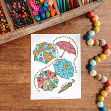 Load image into Gallery viewer, Colorful umbrellas coloring sheet with markers and crayons on a wooden surface
