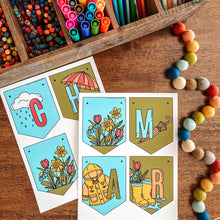 Load image into Gallery viewer, Colorful March banner with markers, pencils, and a letter-themed card on a wooden surface.