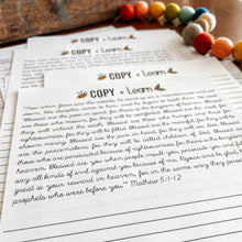 Load image into Gallery viewer, Beatitudes cursive copywork page on a wooden surface with colorful beads.