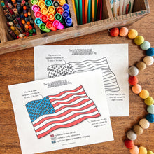Load image into Gallery viewer, Coloring page with American flag design, markers, and crayons on a wooden surface.