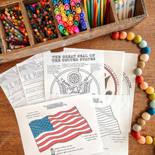 Load image into Gallery viewer, Coloring pages with U.S. flags and seals, markers, and pencils on a wooden surface.