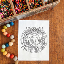 Load image into Gallery viewer, A white coloring page featuring a black line art design of three moths, a crescent moon, and stars with a Bible verse, displayed on a wooden table next to a wooden box of colorful crayons and decorative pom-poms.