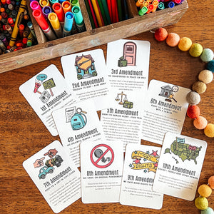 Educational cards about the U.S. Constitution on a wooden surface with markers and pencils.