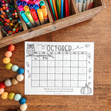 Load image into Gallery viewer, Colorful stationery items including markers, crayons, and colored pencils in a wooden box on a wooden surface with an October calendar printout.
