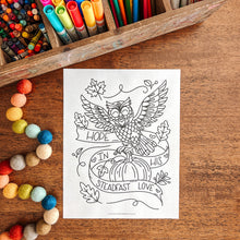 Load image into Gallery viewer, Coloring sheet with owl design on a wooden table with art supplies

