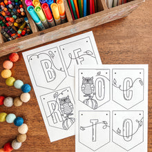 Load image into Gallery viewer, October banner with letter outlines and coloring supplies on a wooden surface
