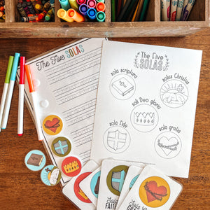 Colorful markers, pencils, and coloring sheets of the Five Solas on a wooden surface