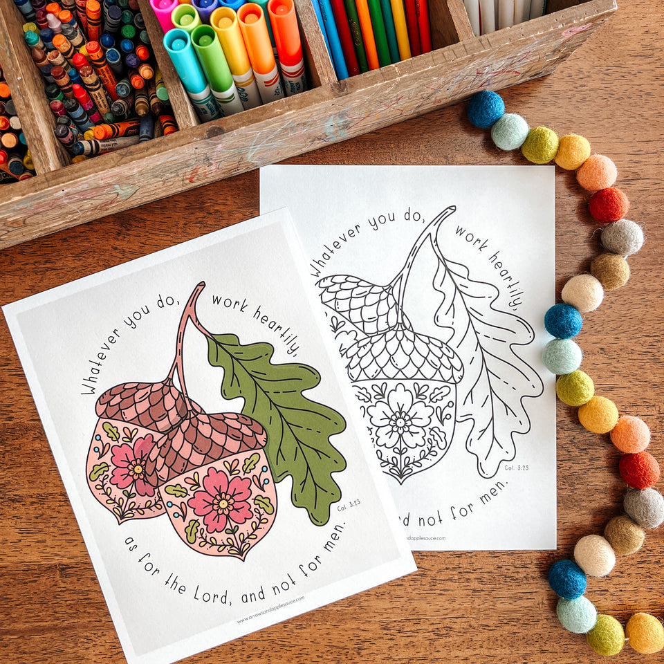 Coloring pages with acorn designs and markers on a wooden surface
