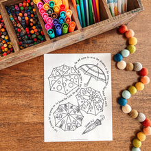 Load image into Gallery viewer, Umbrella coloring page and markers on a wooden surface
