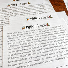 Load image into Gallery viewer, Beatitudes tracing and copywork pages in print and crsive on a wooden surface.
