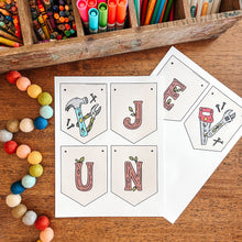 Load image into Gallery viewer, Colorful stationery items including markers, crayons, and a 'June' banner on a wooden surface.
