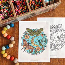 Load image into Gallery viewer, Two printable coloring pages with moths and moon illustrations are displayed on a wooden table, surrounded by colorful pencils in a wooden tray and pastel pom-poms. One page is fully colored, and the other is black-and-white.
