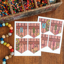 Load image into Gallery viewer, Printed autumn-themed letter banners spelling NOVEMBER laid out on a wooden table, with a box of colorful pencils and a string of wooden beads nearby as styling props.
