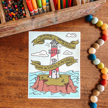 Load image into Gallery viewer, Coloring book page with a lighthouse design on a wooden surface with coloring supplies.
