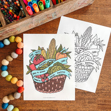 Load image into Gallery viewer, Coloring pages of a fruit and vegetable basket and corn on a wooden surface with markers and pom-poms.
