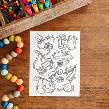 Load image into Gallery viewer, Coloring sheet with vegetable illustrations on a wooden table with art supplies.
