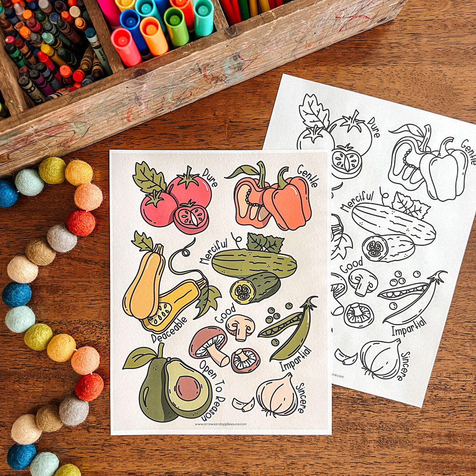 Coloring sheets with vegetable illustrations on a wooden surface with art supplies.